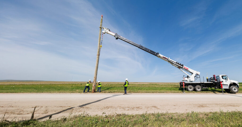 A D100i Digger Derrick is being used to fix a pole in a field