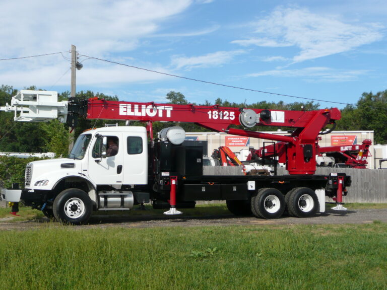 A worker driving a white and red Elliot boom truck