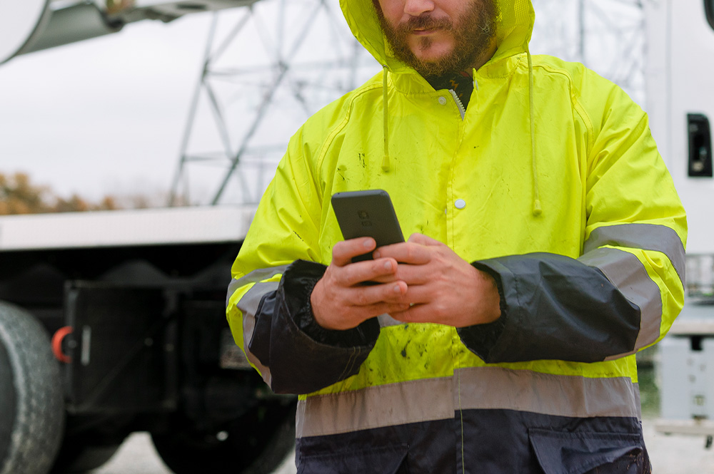 Construction worker using phone for vehicle diagnostics